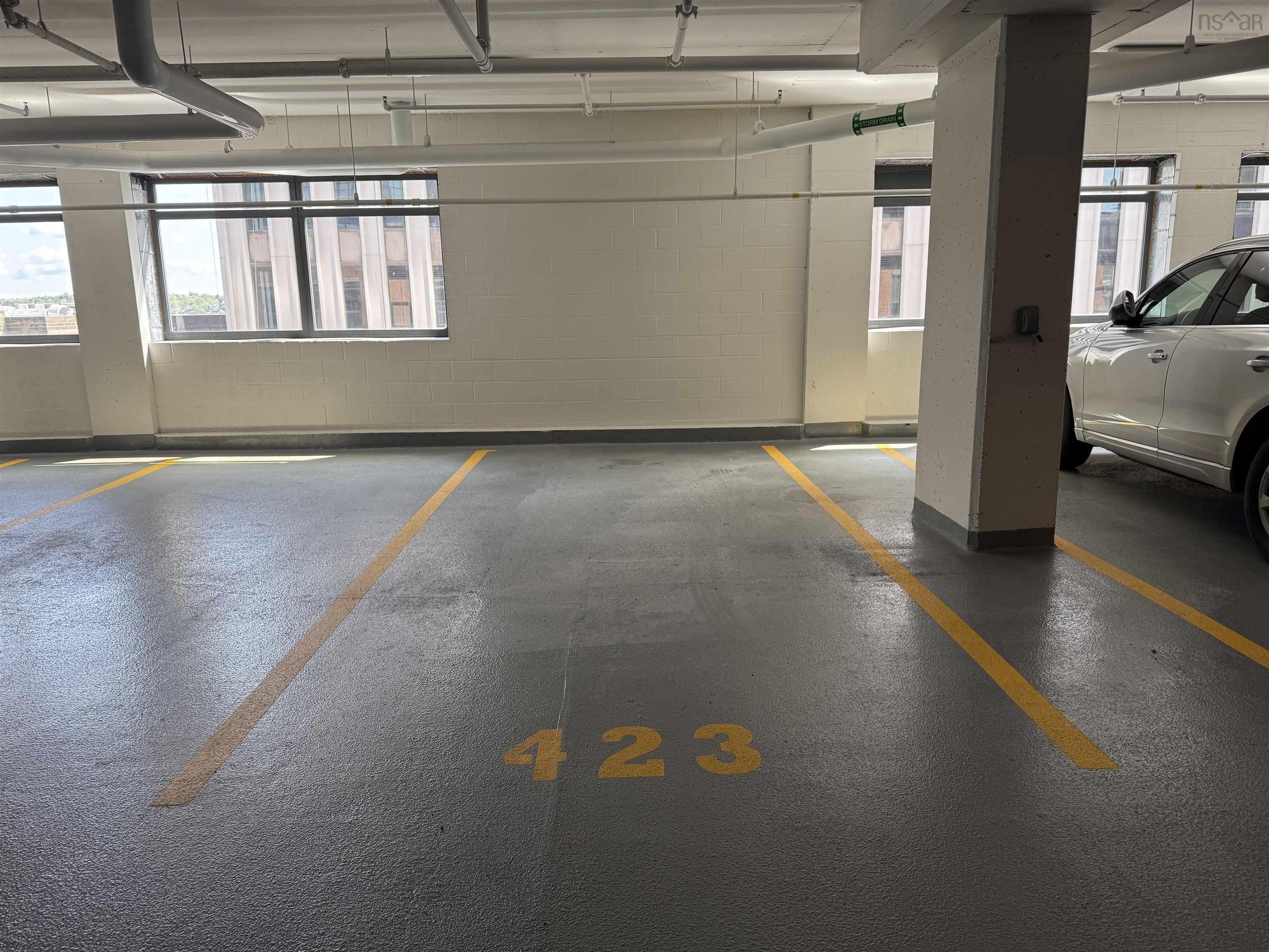 Dedicated parking space featuring painted floor markings and perimeter walls