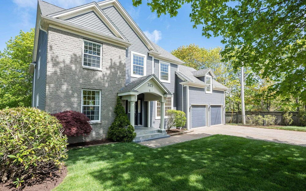 View of front of property featuring concrete driveway and a garage