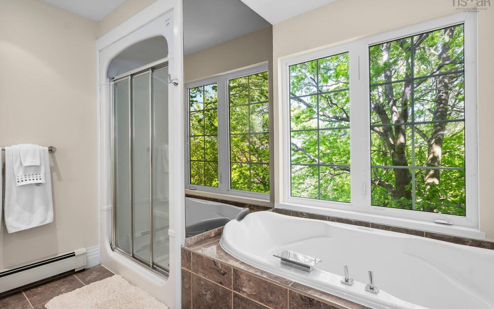 Bathroom featuring a baseboard radiator, a stall shower, a bath, and tile patterned floors