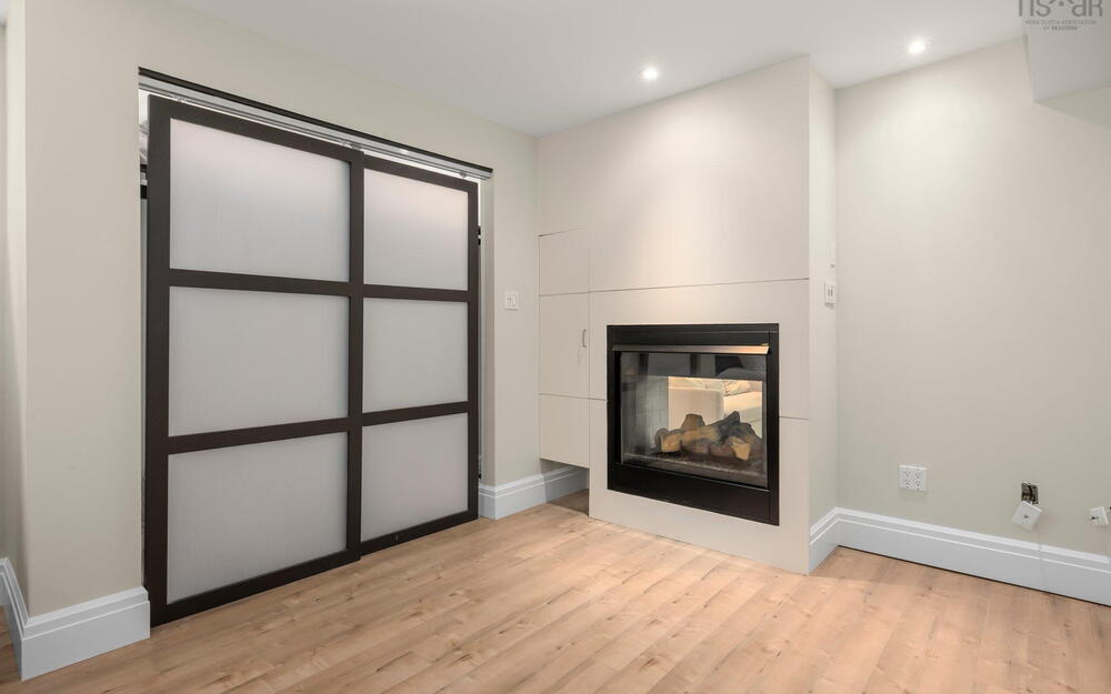 Unfurnished living room featuring wood finished floors, baseboards, a multi sided fireplace, and recessed lighting