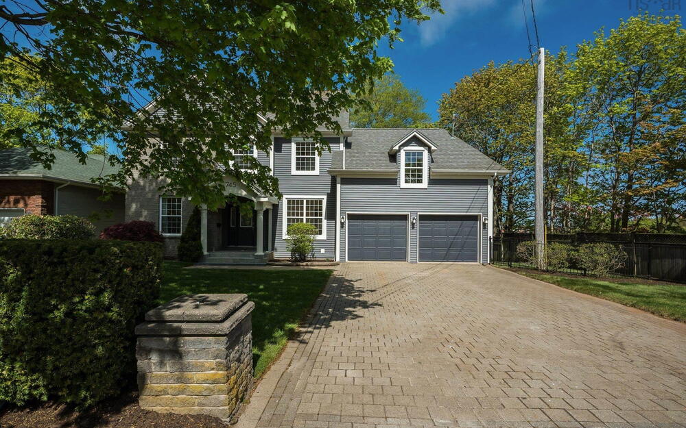 View of front facade with decorative driveway and a garage