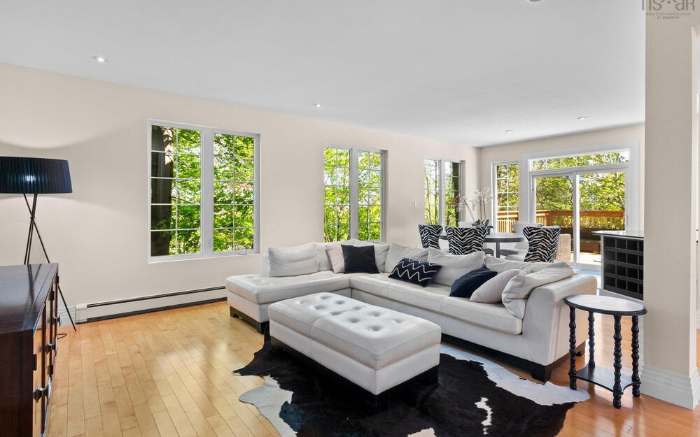 Living area with a baseboard radiator, light wood-style flooring, recessed lighting, and baseboards
