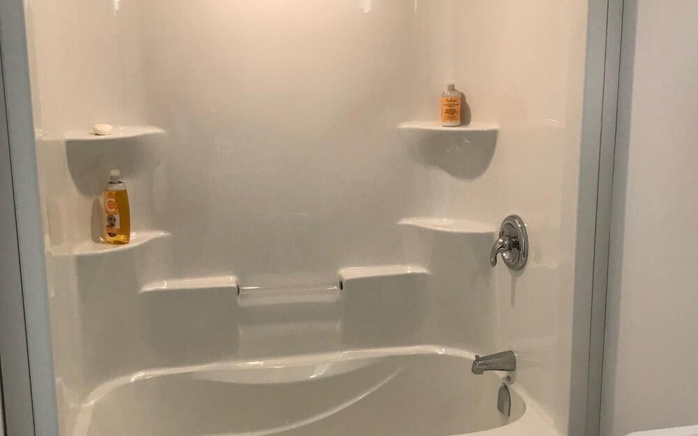 Bathroom with shower / bath combination and wood finished floors