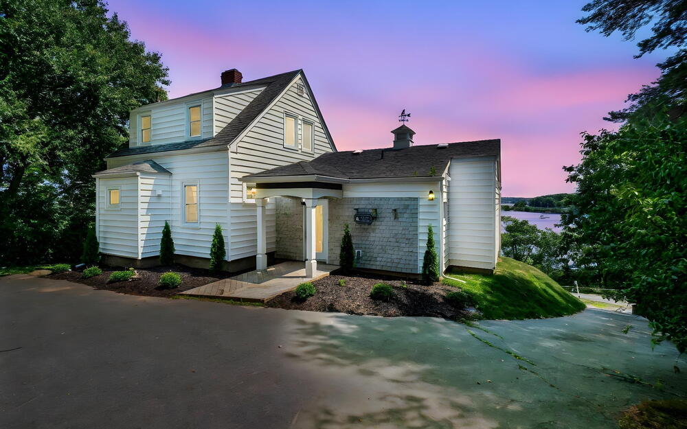 View of front of house featuring a chimney and a shingled roof