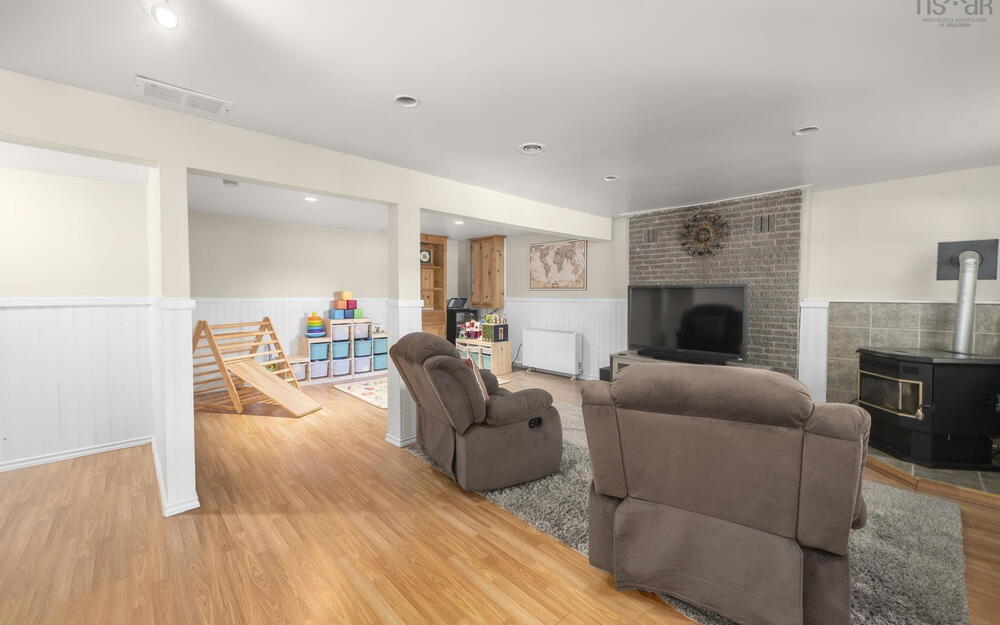 Finished basement featuring wood-finish flooring, recessed lighting, and white wainscoting
