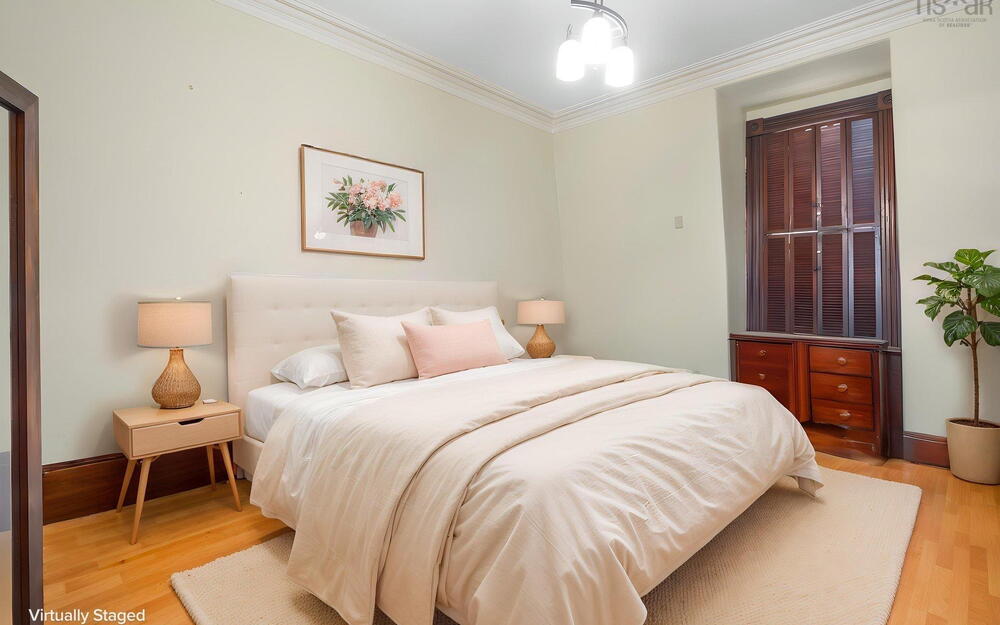 Room featuring natural wood-finish flooring, crown molding, built-in wooden cabinetry, and a window with dark wood shutters