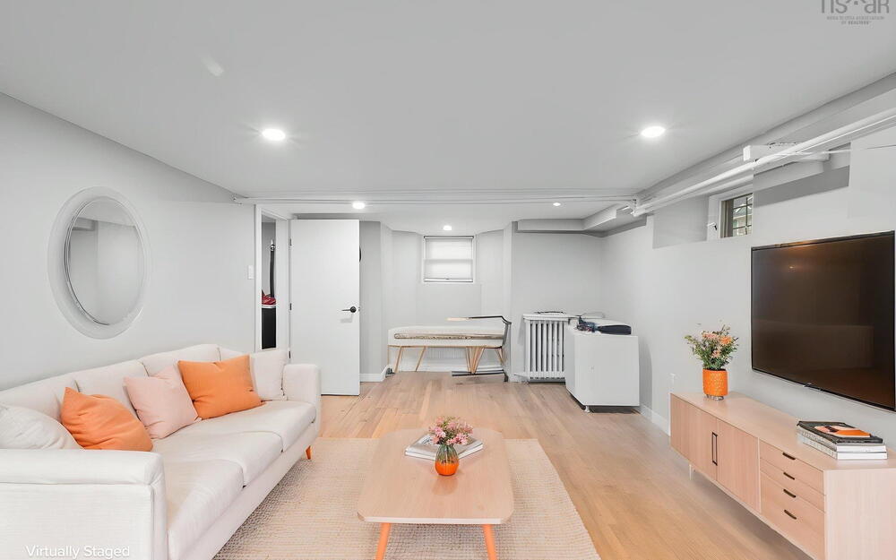 Neutral-toned interior space featuring wood-finish flooring, recessed lighting, and multiple windows