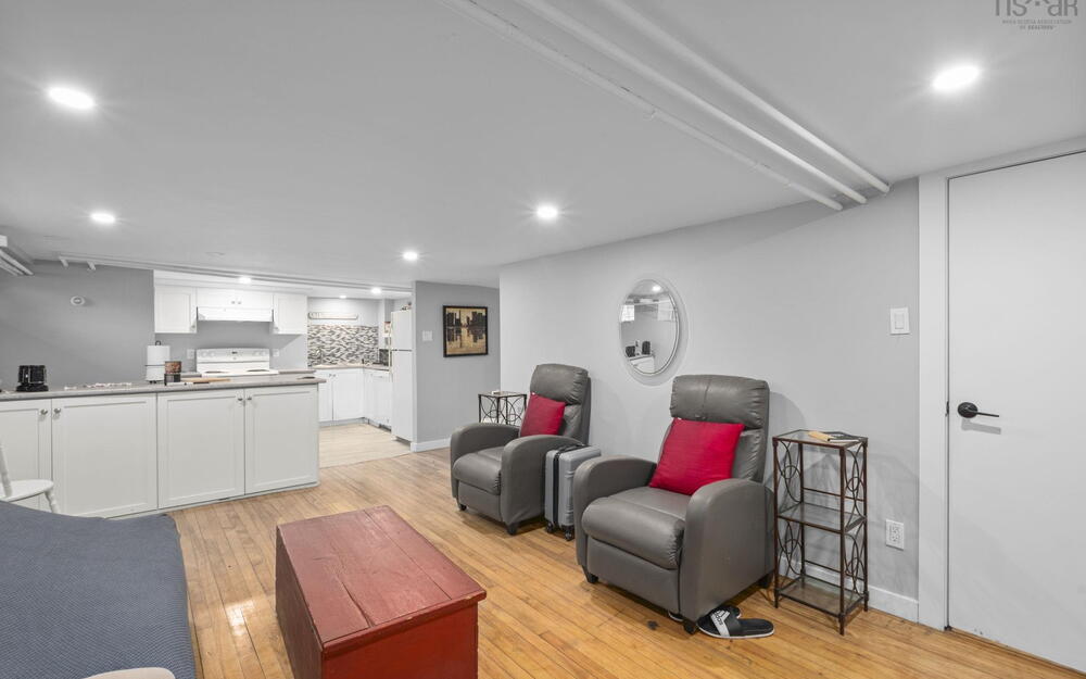 Open-concept interior featuring wood-finish flooring, recessed lighting, white cabinetry, and a neutral color palette