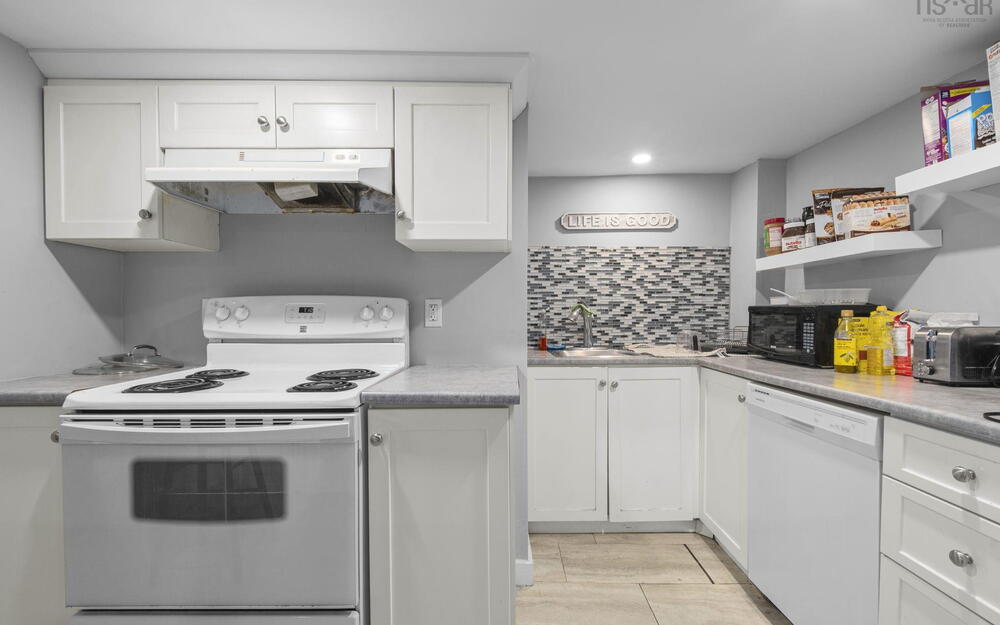 Kitchen featuring white cabinetry, solid-surface countertops, mosaic tile backsplash, built-in range, and dishwasher